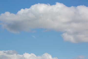 Naklejka na ściany i meble white fluffy clouds on a blue sky background