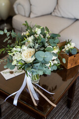 Beautiful tender wedding bouquet with white roses and eustoma flowers on brown wood table