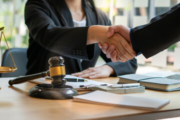 Businessman shaking hands to seal a deal with his partner lawyers or attorneys discussing a...
