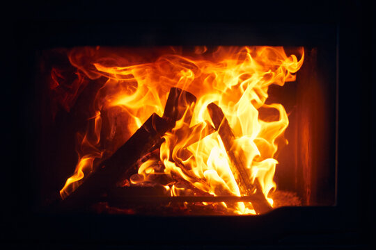 A fire burns in a fireplace, Fire to keep warm. Logs burning in a fireplace