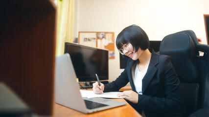 Young adult asian woman using laptop computer for video call work at home on day.