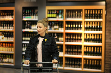 Woman choosing a dairy products at supermarket.woman choosing a wine, champagne at supermarket
