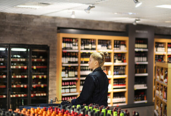 Woman choosing a dairy products at supermarket.woman choosing a wine, champagne at supermarket