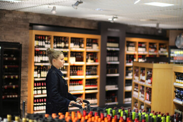 Woman choosing a dairy products at supermarket.woman choosing a wine, champagne at supermarket