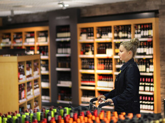 Woman choosing a dairy products at supermarket.woman choosing a wine, champagne at supermarket