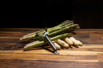 banches of fresh white and green asparagus on wooden background black textspace top view