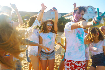 Group of people have fun at the holi festival of colors. Smiling faces in colorful powder. Celebrating traditional indian spring holiday. Party, vacation concept. Friendship and celebration concept.