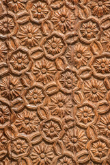 Woodcarving with floral motifs as detail of old wooden door closeup
