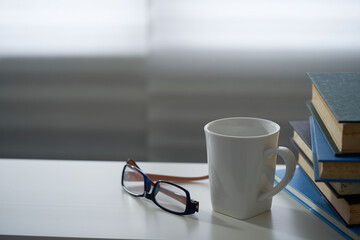stack of  book and cup coffee  by window ,morning