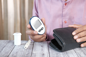 man's hand putting glucose meter in a small bag 