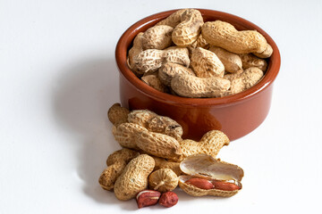 Cacahuètes dans une coupelle sur fond blanc