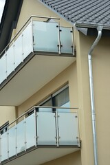 Balkon an moderner Hausfront mit Edelstahl-Glas-Geländer als Sichtschutz
