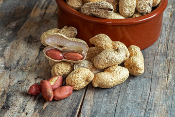 Cacahuètes dans une coupelle sur fond de  vieilles planches en bois