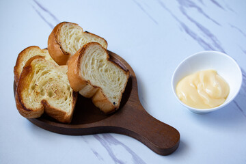 Toast in wooden plate with cheese on gray background