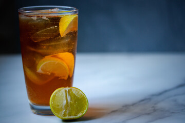 Thai style sweet iced lemon tea on a gray background.