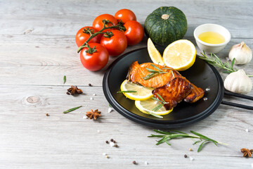 Grilled salmon steak on vintage wooden board with fork, olive oil, vegetables, herbs and spices on dark concrete background. Raw salmon fillet with vegetables, spices and lemon on wooden table. - 428418648