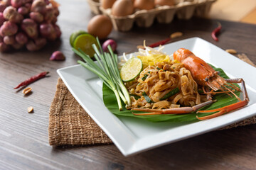 Pad Thai with fresh shrimp on a wooden table Pad Thai is a delicious Thai street food. And popular people around the world