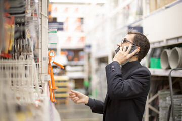 A man in a hardware store talking on the phone