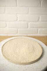 white rice Thai in a white round plate on a wooden background. Selective focus