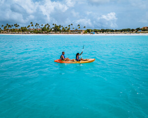 Couple Kayaking in the Ocean on Vacation Aruba Caribbean sea, man and woman mid age kayak in ocean...
