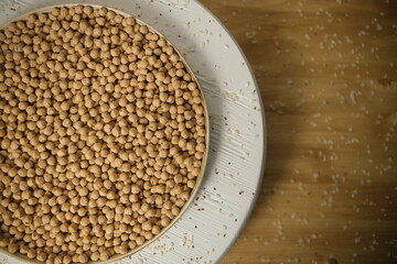 Raw chickpeas, rotation. Chickpeas, close-up. In a plate on a wooden table. Selective focus
