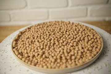 Raw chickpeas, rotation. Chickpeas, close-up. In a plate on a wooden table. Selective focus