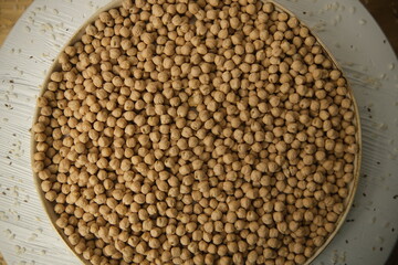Raw chickpeas, rotation. Chickpeas, close-up. In a plate on a wooden table. Selective focus