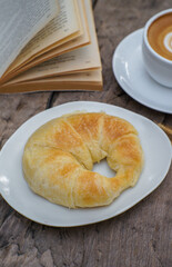 Croissant and cup of cappuccino coffee on table