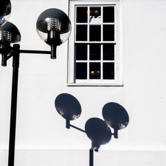 Modern Street Lighting Casting A Shadow On A White Wall In Summer Sunshine With No People