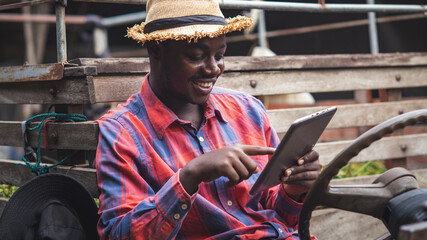 African farmer using tablet and smiling while sitting in the tractor.Agriculture or cultivation concept