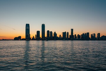 View of the Jersey City skyline and Hudson River at sunset, from the Financial District, Manhattan, New York City