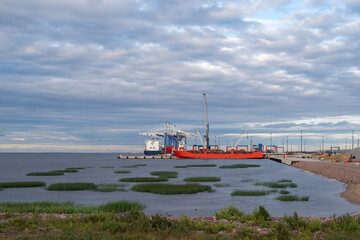 The container ship is loaded at the river cargo port.