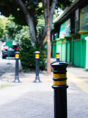 the road dividing stand bollard is black and yellow at the end