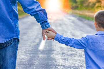 A Happy parent with a child in the park hands on nature travel go along the road