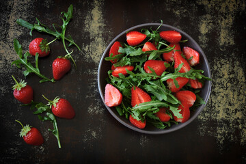 Healthy salad with arugula and strawberries.