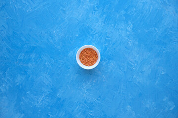 Fototapeta na wymiar Red lentils close-up. Background with lots of lentils. Minimalism. Blue background. Top view. Soft focus