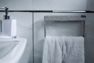 Detailaufnahme eines Badezimmers. Angefertigter strassbesetzter Handtuchhalter, Handtuchring mit  weißem Handtuch - obrazy, fototapety, plakaty