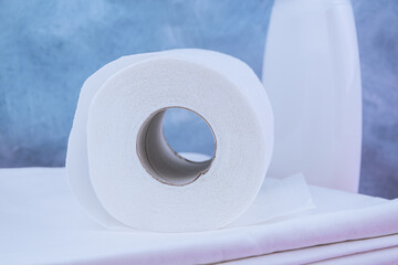 Roll of toilet paper on white bed linen. Cleanliness in hotel room, care for guests. Body hygiene, help with diarrhea