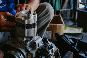Fototapeta premium Mechanic is working on a two-stroke engine cylinder head.