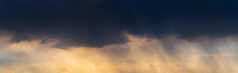 Fototapeta na wymiar Dark storm clouds in the evening sky at sunset