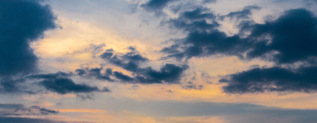Dramatic sky with dark clouds at sunset. Panorama