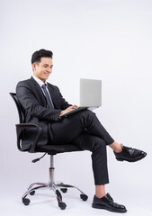 Young Asian businessman sitting on chair on white background