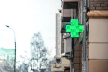 Poster Green pharmacy cross on corner of building © Koirill