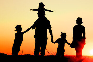 Obraz premium A Happy family by the sea at sunset in travel silhouette in nature
