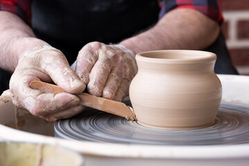 Fototapeta na wymiar Potter wheel and hands of craftsman making a jug