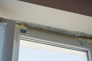 Installation of windows. Polyurethane foam on the slope of the window. Sealing window slopes.