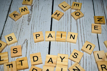 Wooden blocks with letters forming word "pain"