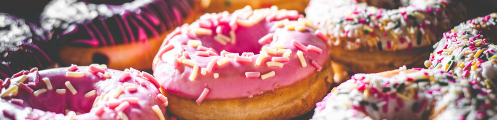 Assorted sweet donuts in a paper box.