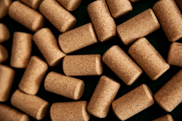 Many of cork plugs for the wine bottle in detail. Background texture of a randomly scattered pile of assorted wine corks. Wine and alcohol theme.