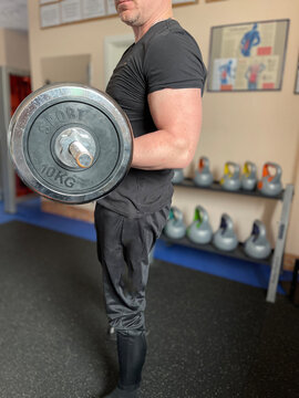 Older Man Lifting Weights On A Barbell In A Gym